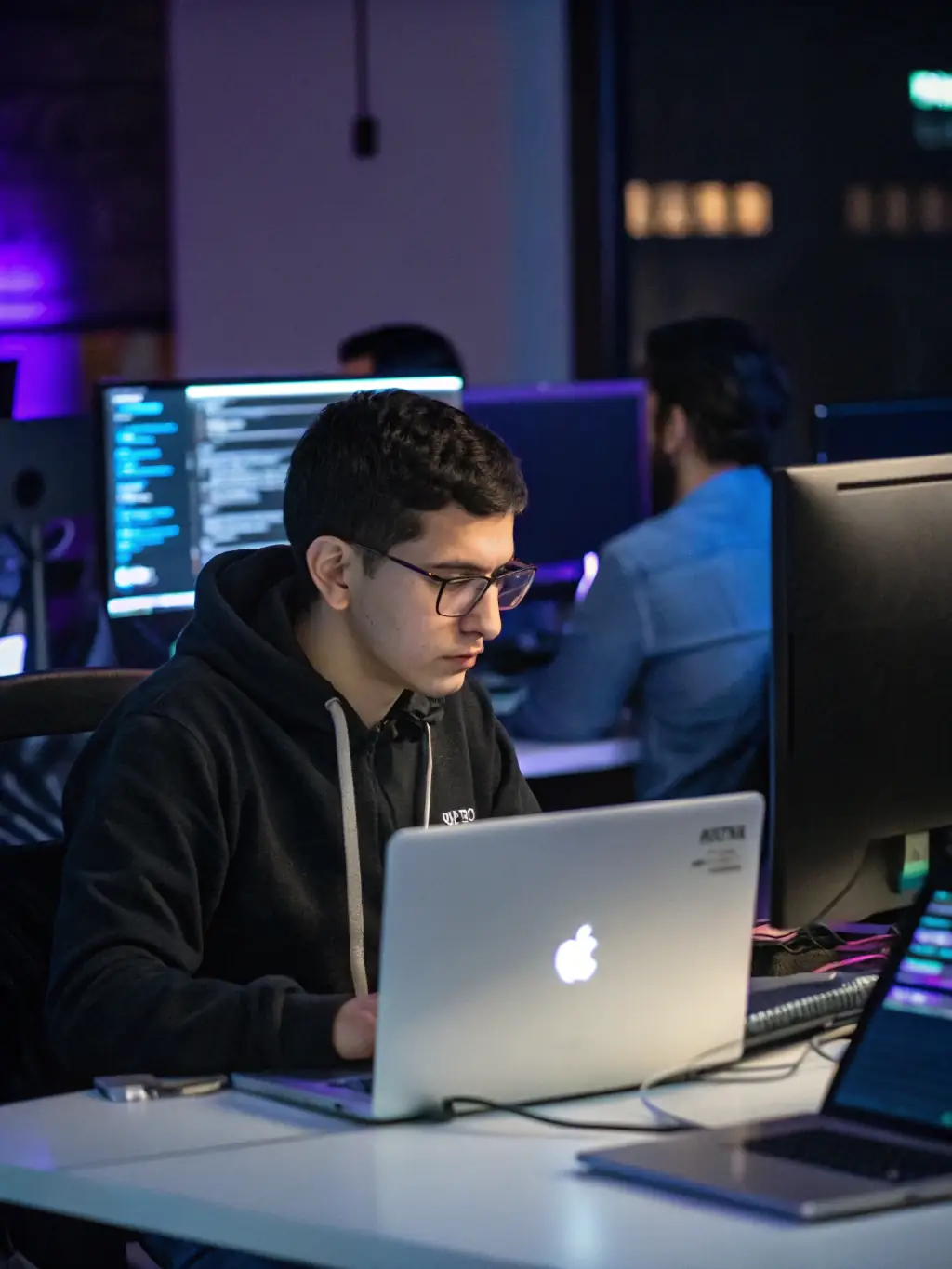 A backend developer working on a server code with multiple monitors displaying code snippets, database diagrams, and server architecture. The environment is focused and technical, emphasizing backend development, representing the Custom Backend Development package.